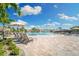 Relaxing community pool with a waterfall feature, lounge chairs, umbrellas, and tropical landscaping at 5931 Wake Forest Run # 104, Bradenton, FL 34211
