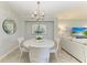 Cozy dining area with a round table, modern chandelier, and serene decor at 5931 Wake Forest Run # 104, Bradenton, FL 34211