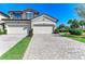 Charming townhome featuring a two-car garage, stone accents, and well-manicured landscaping at 5931 Wake Forest Run # 104, Bradenton, FL 34211