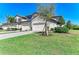 Inviting home exterior with lush green lawn and a paver driveway leading to a two-car garage at 5931 Wake Forest Run # 104, Bradenton, FL 34211