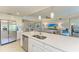 Open kitchen concept with quartz island, stainless steel appliances, and views of the living and dining areas at 5931 Wake Forest Run # 104, Bradenton, FL 34211