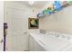 Bright laundry room with washer, dryer, and storage shelves at 5931 Wake Forest Run # 104, Bradenton, FL 34211