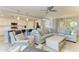 Open concept living area with a large sectional sofa and modern kitchen with stainless steel appliances and breakfast bar at 5931 Wake Forest Run # 104, Bradenton, FL 34211