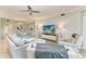 Bright, airy living room featuring modern furnishings, a ceiling fan, and a large television for comfortable relaxation at 5931 Wake Forest Run # 104, Bradenton, FL 34211