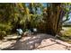 Paver patio shaded by mature trees in a peaceful backyard setting at 640 Fox St, Longboat Key, FL 34228