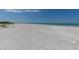 Expansive white sand beach meeting tranquil turquoise waters under a clear blue sky, ideal for serene getaways at 640 Fox St, Longboat Key, FL 34228