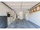Spacious garage interior with washer/dryer hookups, shelving units and access door at 640 Fox St, Longboat Key, FL 34228