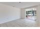 Empty room with tile floors, patio door to screened porch and light from windows at 640 Fox St, Longboat Key, FL 34228