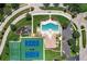 Aerial shot featuring community pool, playground, tennis, and basketball courts surrounded by green landscape and roads at 6709 Rock Bridge Ln, Ellenton, FL 34222