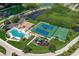 Aerial view showcases community amenities, featuring pool, tennis and basketball courts, playground, and lush landscaping at 6709 Rock Bridge Ln, Ellenton, FL 34222