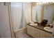 Bright bathroom with double sinks, a vanity, and a shower-tub combo behind a decorative curtain at 6709 Rock Bridge Ln, Ellenton, FL 34222