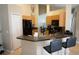 Eat-in kitchen featuring black appliances, wood cabinets, and breakfast bar seating at 6709 Rock Bridge Ln, Ellenton, FL 34222