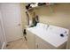 Functional laundry room with washer, dryer, storage shelves, and a door leading to other areas at 6709 Rock Bridge Ln, Ellenton, FL 34222