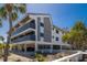 Exterior angle shot showing the raised beach condo with multiple decks, blue windows, and tropical landscaping at 6804 Gulf Dr # 6804, Holmes Beach, FL 34217