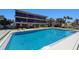 A pool view with clear blue water, tables and lounge chairs under a bright sky at 6804 Gulf Dr # 6804, Holmes Beach, FL 34217