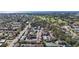 Expansive aerial view showcasing the neighborhood, golf course, and distant water views at 6881 Whitman Way, Sarasota, FL 34243