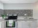 Close-up of the kitchen showcasing stainless steel appliances, tile backsplash, and granite countertops at 6881 Whitman Way, Sarasota, FL 34243