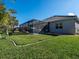 Lush backyard with well-maintained lawn, stylish landscaping, and a screened-in pool area at 7095 Tamworth Pkwy, Sarasota, FL 34241