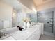 Bathroom with double sink vanity, quartz countertops, framed mirrors and a glass shower with tile surround at 7095 Tamworth Pkwy, Sarasota, FL 34241