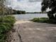 Gravel boat ramp leading into a calm lake, framed by lush greenery at 7095 Tamworth Pkwy, Sarasota, FL 34241