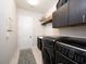 Functional laundry room with washer, dryer, sink, and storage cabinets at 7095 Tamworth Pkwy, Sarasota, FL 34241
