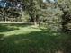 Expansive green lawn near pond surrounded by trees at 7095 Tamworth Pkwy, Sarasota, FL 34241
