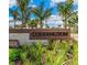 Coddington community entrance sign shows lush landscaping, a combination of stone and brown wooden background under palm trees at 732 157Th E Ct, Bradenton, FL 34212