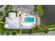 Aerial view of a community pool with lounge chairs, palm trees, and well-maintained landscaping next to a parking area at 7730 34Th W Ave # 103, Bradenton, FL 34209