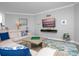 Bright living room features a comfortable couch, decor, and large wall-mounted television for entertainment at 7730 34Th W Ave # 103, Bradenton, FL 34209