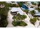 Aerial view of a home with lush tropical landscaping and waterfront access on a canal at 807 S Bay Blvd, Anna Maria, FL 34216