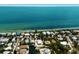 Stunning aerial view of beachfront homes with private canals and lush landscaping along the clear ocean waters at 807 S Bay Blvd, Anna Maria, FL 34216