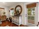 Bright bedroom with hardwood floors, stylish dresser, charming mirror, and access to the outdoor deck at 807 S Bay Blvd, Anna Maria, FL 34216