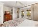 Bedroom with french doors leading to a balcony and dresser with a television at 807 S Bay Blvd, Anna Maria, FL 34216