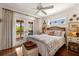 Bright bedroom with french doors leading to a balcony and a decorative ceiling fan at 807 S Bay Blvd, Anna Maria, FL 34216
