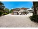 Charming elevated stilt home featuring a convenient garage, covered balconies, and white gravel driveway at 807 S Bay Blvd, Anna Maria, FL 34216