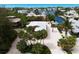 Beautiful canal-front property with private dock, palm trees, white gravel drive, and manicured landscaping at 807 S Bay Blvd, Anna Maria, FL 34216