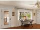 Bright living room area with hardwood floors, black table, and large windows showcasing outdoor greenery at 807 S Bay Blvd, Anna Maria, FL 34216