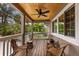 Relaxing outdoor porch featuring a ceiling fan and wicker furniture surrounded by lush greenery at 807 S Bay Blvd, Anna Maria, FL 34216