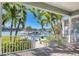 Balcony overlooking pool and waterway, surrounded by lush landscaping and tropical palm trees at 810 Siesta Dr, Sarasota, FL 34242