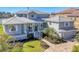 Beautiful two-story home with a metal roof, lush landscaping, and brick-paver driveway at 810 Siesta Dr, Sarasota, FL 34242
