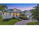 Charming two-story home with lush landscaping, a brick driveway, and a welcoming front porch at 810 Siesta Dr, Sarasota, FL 34242