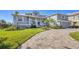 Charming home showcasing manicured lawn, lush landscaping, and a welcoming front porch at 810 Siesta Dr, Sarasota, FL 34242