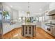 Open kitchen featuring a large island, stainless steel appliances, and hardwood floors at 810 Siesta Dr, Sarasota, FL 34242