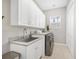 Spacious laundry room with ample storage, utility sink, and front load washer and dryer at 810 Siesta Dr, Sarasota, FL 34242
