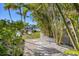 Beautiful stone path leading to the canal with lush tropical landscaping and serene water views at 810 Siesta Dr, Sarasota, FL 34242