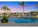 Heated pool and spa illuminated at twilight, nestled by a boat dock and lush greenery at 810 Siesta Dr, Sarasota, FL 34242