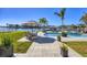 Beautiful outdoor area with a sparkling pool, dining set, and lush landscaping with water view at 810 Siesta Dr, Sarasota, FL 34242