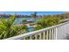 Scenic waterfront view from the property featuring a private dock, pool, and lush landscaping at 810 Siesta Dr, Sarasota, FL 34242