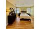 Comfortable bedroom with hardwood floors, ceiling fan, neutral-toned walls, and a large dresser at 8351 38Th Street E Cir # 302, Sarasota, FL 34243
