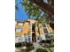 Inviting mustard colored condo building with mature trees and tidy landscaping on a bright, sunny day at 8351 38Th Street E Cir # 302, Sarasota, FL 34243